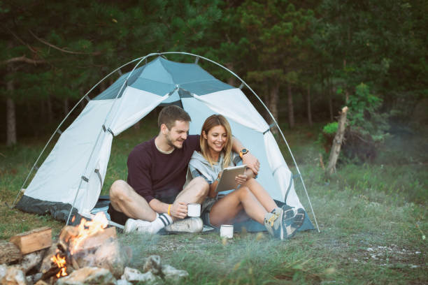 istock Happy Young Couple Using Digital Tablet In Camping Trip 1073002442