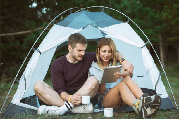 istock Happy Young Couple Using Digital Tablet In Camping Trip 1073002522