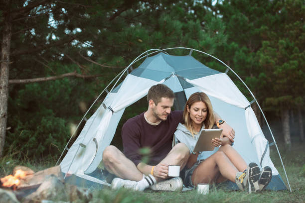 istock Happy Young Couple Using Digital Tablet In Camping Trip 1073002524