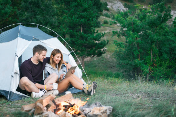 istock Happy Young Couple Using Digital Tablet In Camping Trip 1073002572