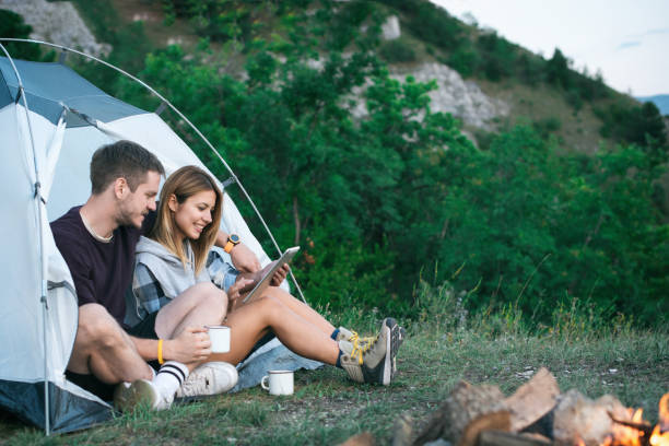 istock Happy Young Couple Using Digital Tablet In Camping Trip 1073002752