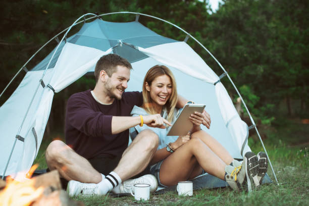 istock Happy Young Couple Using Digital Tablet In Camping Trip 1073003914