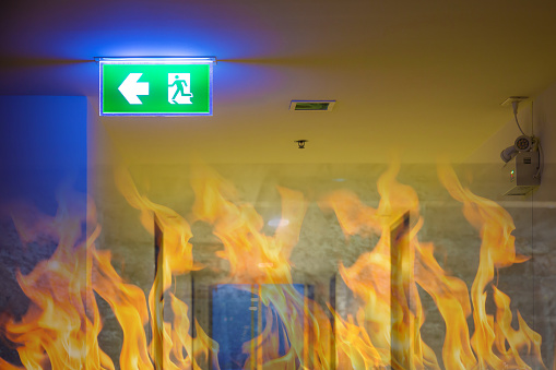 Green emergency exit sign showing the way to escape.Fire exit in the building.
