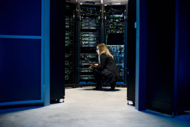 istock Female IT Professional Working in Server Room With Laptop 1073009160