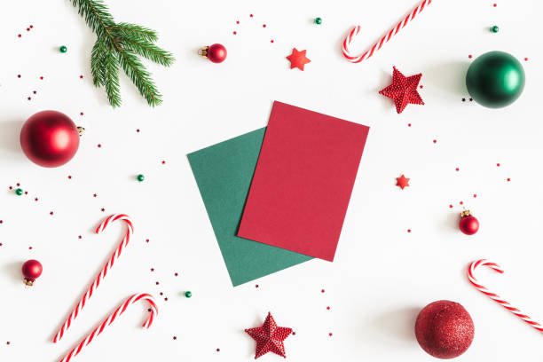 Christmas composition. Paper blank, fir tree branches, red and green decorations on white background. Christmas, winter, new year concept. Flat lay, top view, copy space