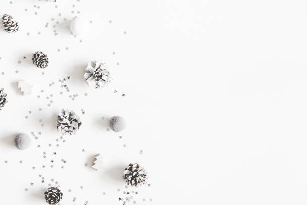 istock Christmas composition. Christmas white and silver decorations, pine cones on white background. Flat lay, top view, copy space 1073017484