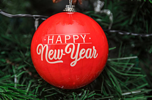 istock Christmas tree hanging ornament, red globe with write happy new year, close up 1073021316