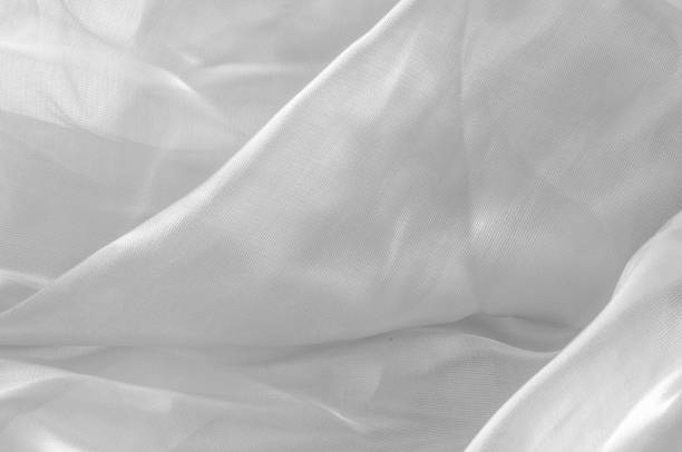 istock Background texture, pattern. The fabric is white. White silk fabric background elegant and delicate. Bright satin fabric, folded for use as a background. Upper type of fabric Textile surface. 1073025348
