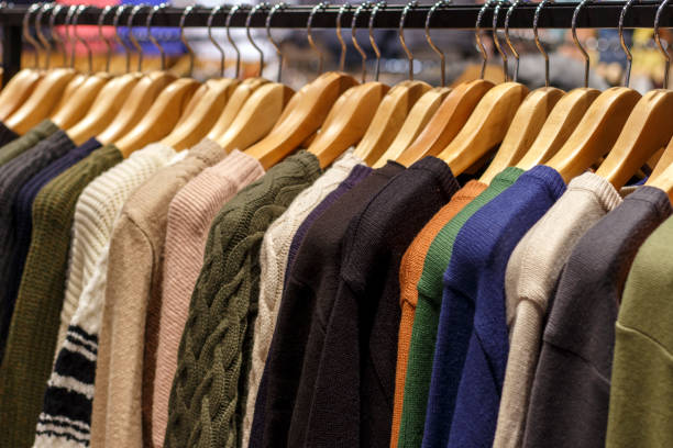 istock Multicolored woolen knitted sweaters hanging on hangers close-up, side view 1073028716