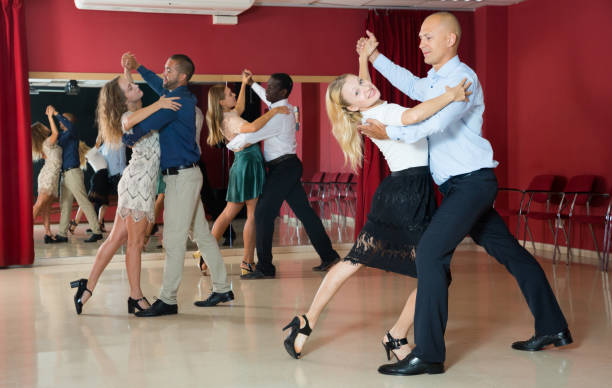 istock Positive adult couples dancing tango together  in modern studio 1073028766