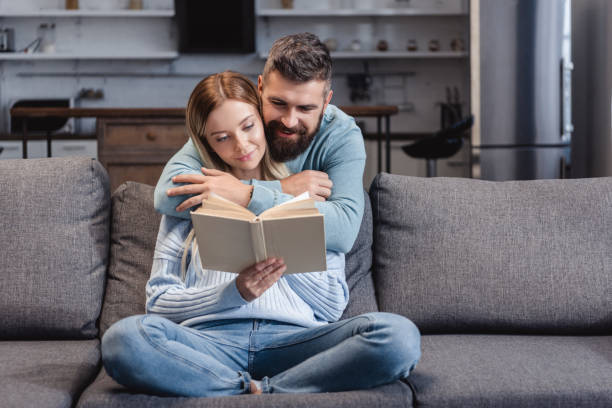 istock Cheerful husband hugging attractive wife with book 1073032452