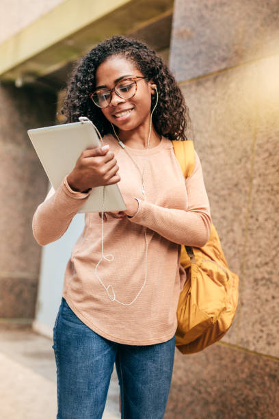 istock International student with backpack, headphones and digital gadgets 1073033696