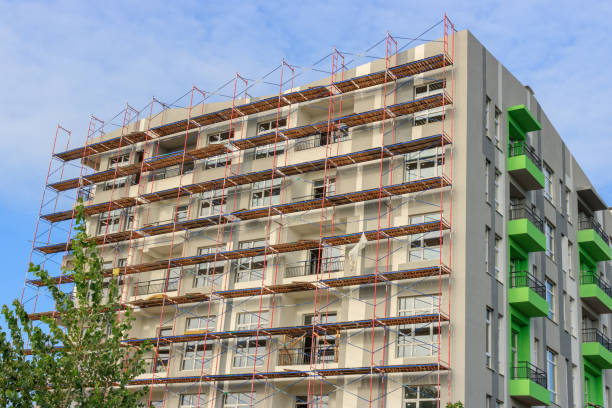 istock Facade of building under construction with scaffolding against blue sky 1073035250