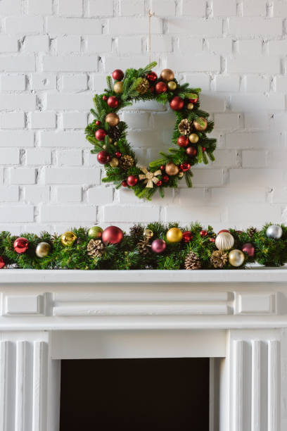 istock festive christmas wreath over fireplace mantel with white brick wall 1073043962