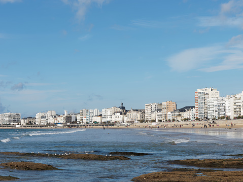 Les Sables d'Olonne, seafront a sunny day in autumn, white buildings and crescent form sand beach, France