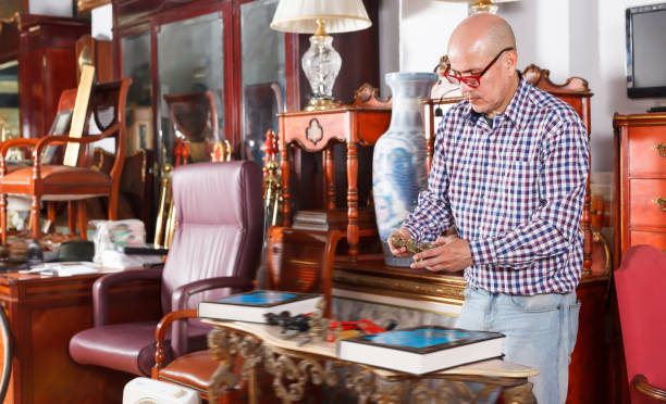 istock Positive male carefully examining antiques 1073048446