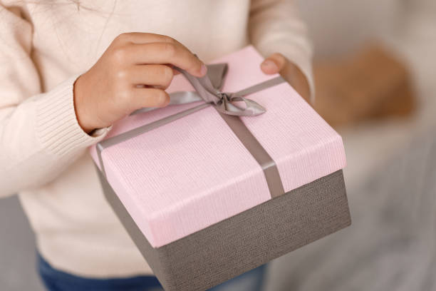 istock Child hands holding beautiful pink gift box 1073055188