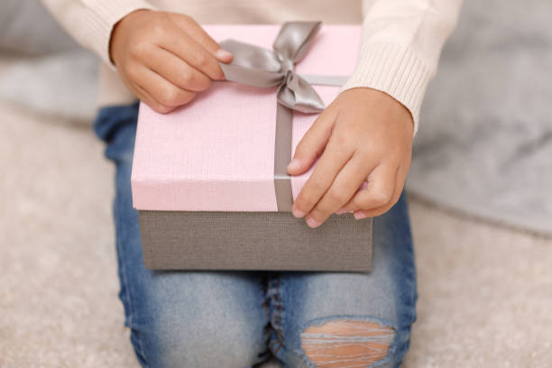 istock Child hands holding beautiful pink gift box 1073055230