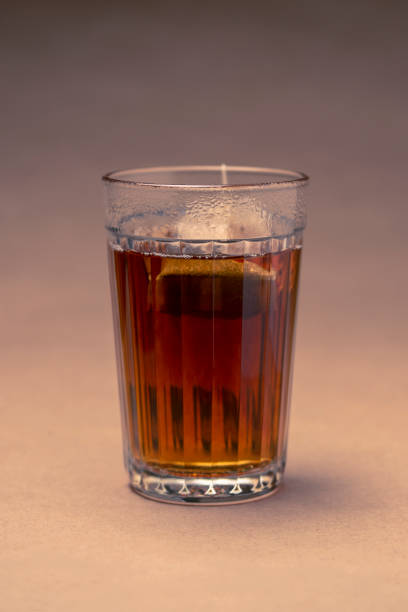 istock Glass with black tea on a brown background 1073055266