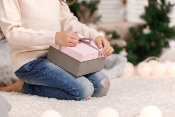 istock Child hands holding beautiful pink gift box 1073055294