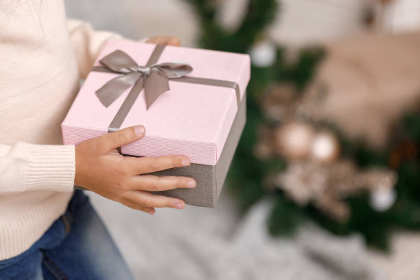 istock Child hands holding beautiful pink gift box 1073055378