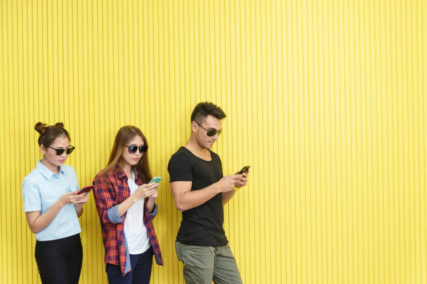istock Group of young people using smartphone on wall. Network connection technology concept with free space. 1073057472