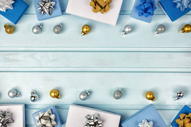 istock Christmas composition, copy space. Silver and gold Christmas balls, blue and white gift boxes decorated with bows. Festive layout on a light blue background. 1073058560