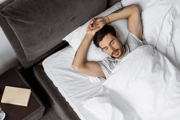 istock top view of handsome bearded young man sleeping in bed 1073071168