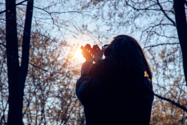 Woman with praying hands in nature / forest.