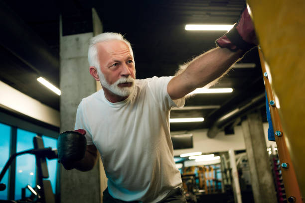 Senior in gym boxing Senior in gym boxing old man boxing stock pictures, royalty-free photos & images