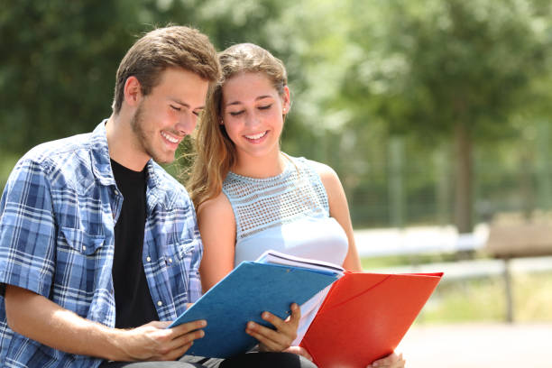 istock Couple of students studying together in a campus 1073083966