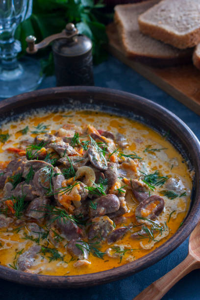 istock Chicken hearts stewed in sour cream in a clay bowl, selective focus 1073084020