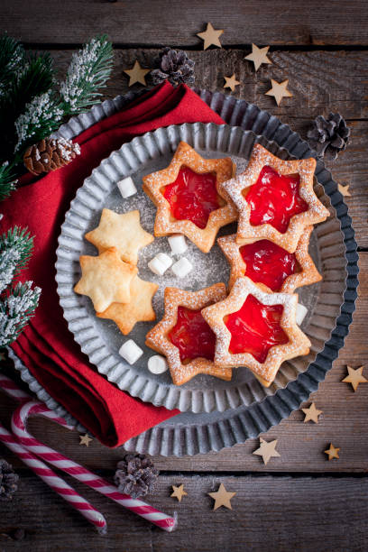 istock Christmas cookies. Linzer cookies with raspberry jam on green table background. Traditional Austrian biscuits filled. Top view and copy space 1073084236