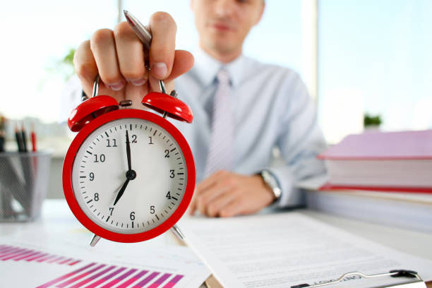 istock Male hand on the alarm clock a red 1073095466