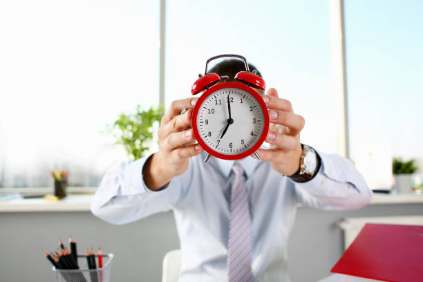 istock Male hand on the alarm clock a red 1073095484