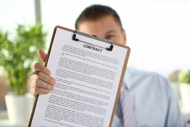 istock Male arm in suit offer contract form on 1073095504