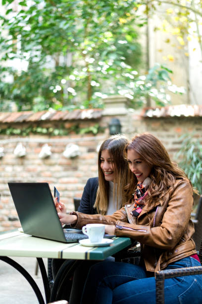 istock Two girlfriends are shopping online in the cafeteria 1073095658