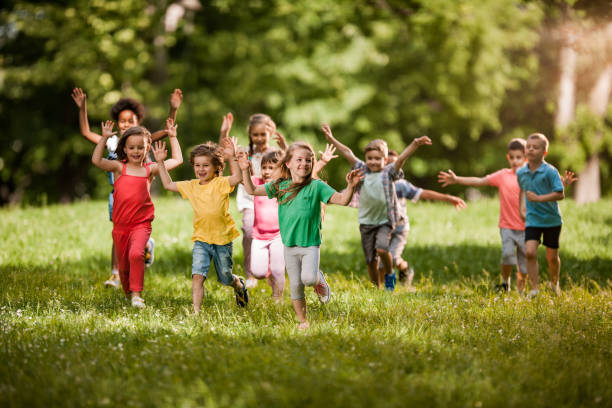 istock Large group of happy kids having fun while running in springtime. 1073097872