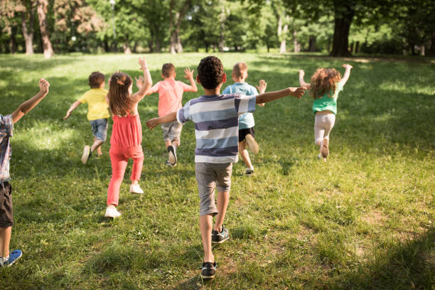istock Back view of carefree kids having fun while running in springtime. 1073098560