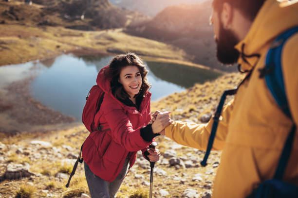 istock Helping hand - hiker woman getting help on hike happy overcoming obstacle. 1073098610