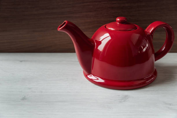 istock Red teapot on wooden background 1073100090