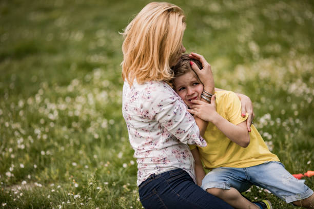 istock Mother consoling her crying son at the park. 1073103246