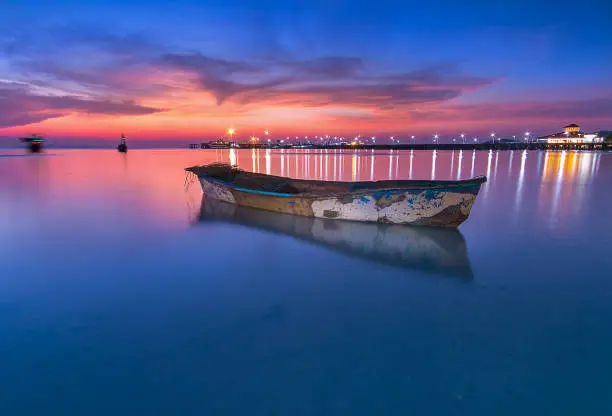 A beautifull sunset with the little boat in the blue sea