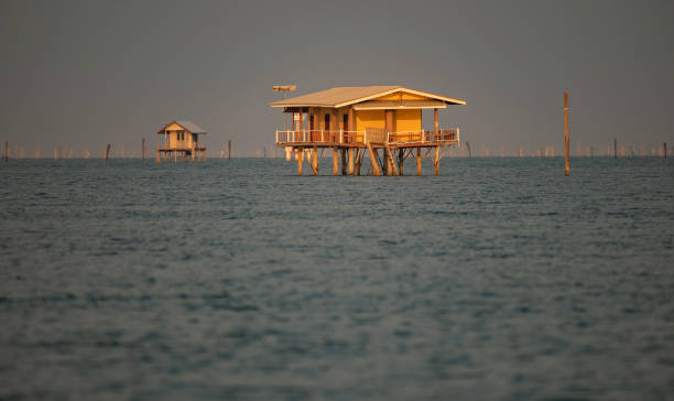 Yellow house in the sea with smooth wave during sunset