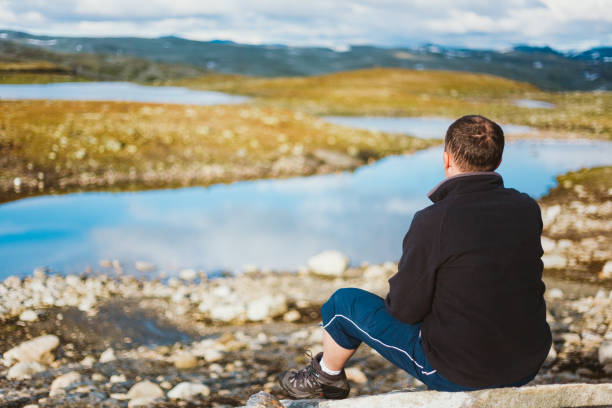 istock Rear View Of Man Looking At Lake 1073115326