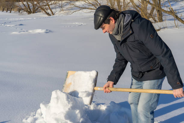 istock Handsome middle-aged caucasian man cleans snow on household plot in sunny day. Man with shovel paving path from country house to road. Winter active leisure concept 1073116786