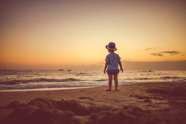 Happy child enjoying sunset near the sea