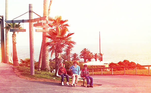 Vintage family doing tourism Vintage image of a mother and her children sitting in a park 1980 photos stock pictures, royalty-free photos & images