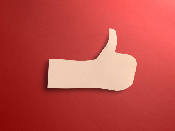 istock Thumbs up paper craft with shadow on red background 1073141648