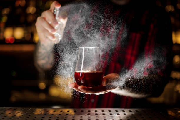 Bartender spraying on the Sazerac cocktail in the bar
